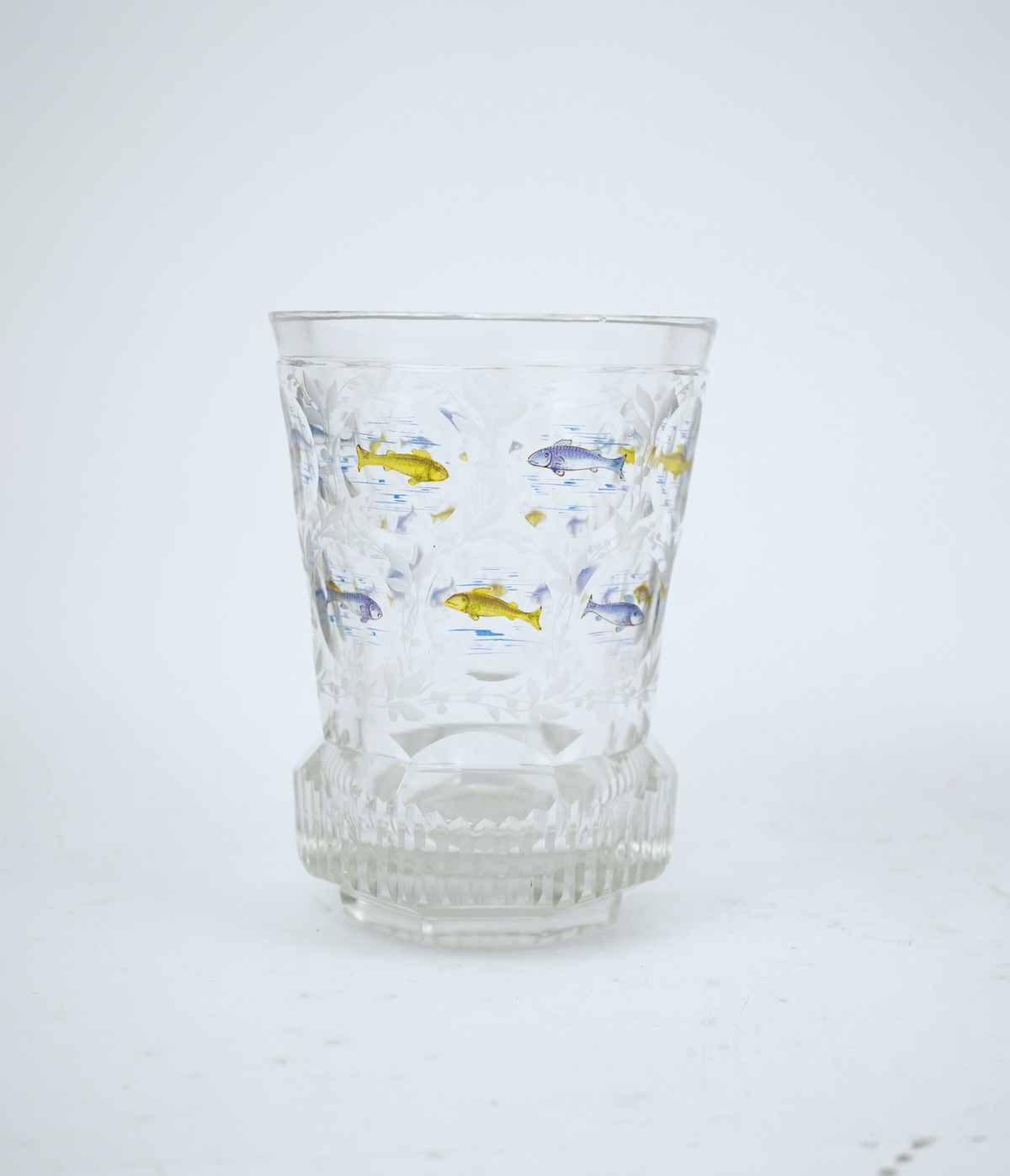 Two Bohemian transparent enamelled ‘fish’ beakers, and a similar faceted goblet, c.1840-60